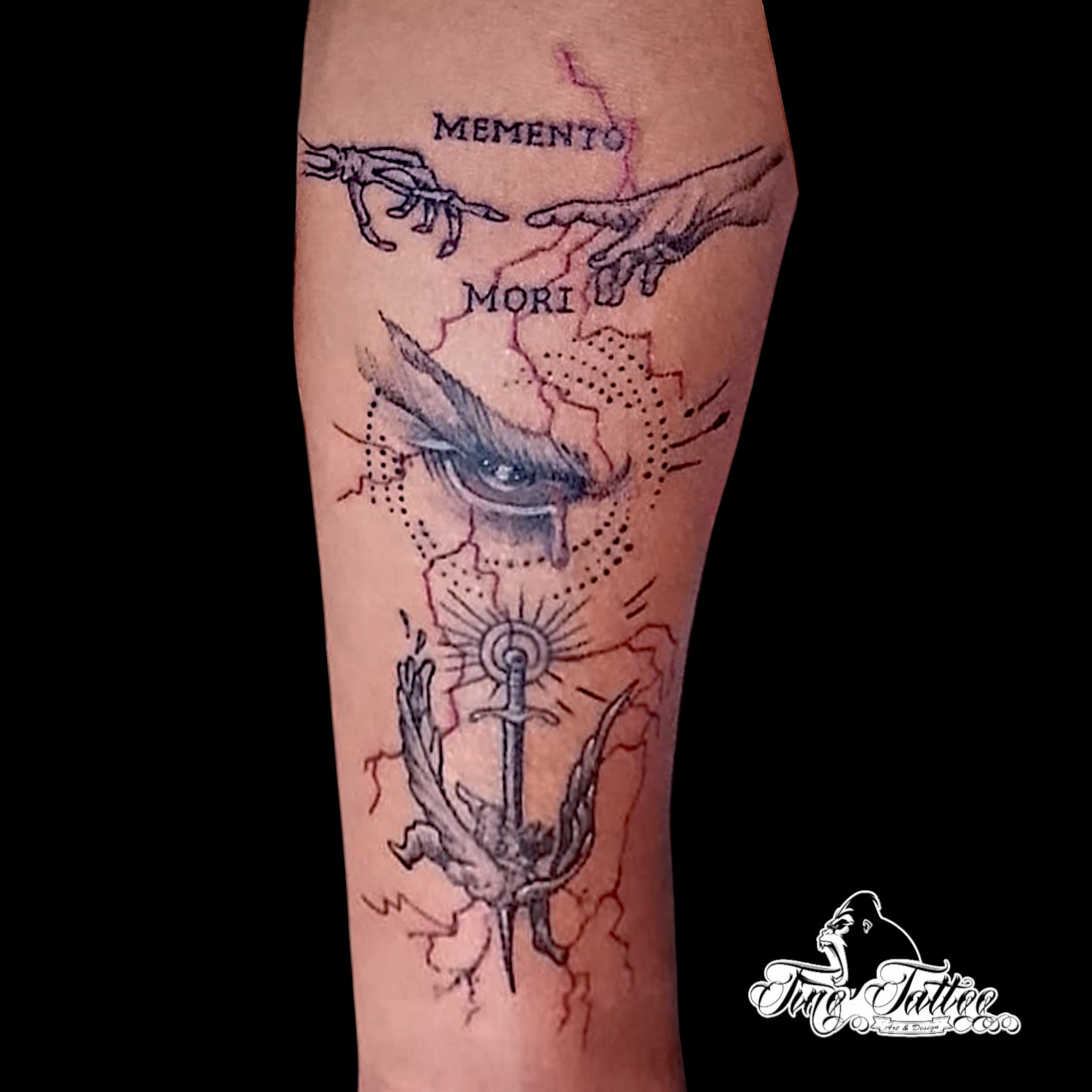 Tatuaje fineline con manos, lettering memento mori, ojo central y ancla alada