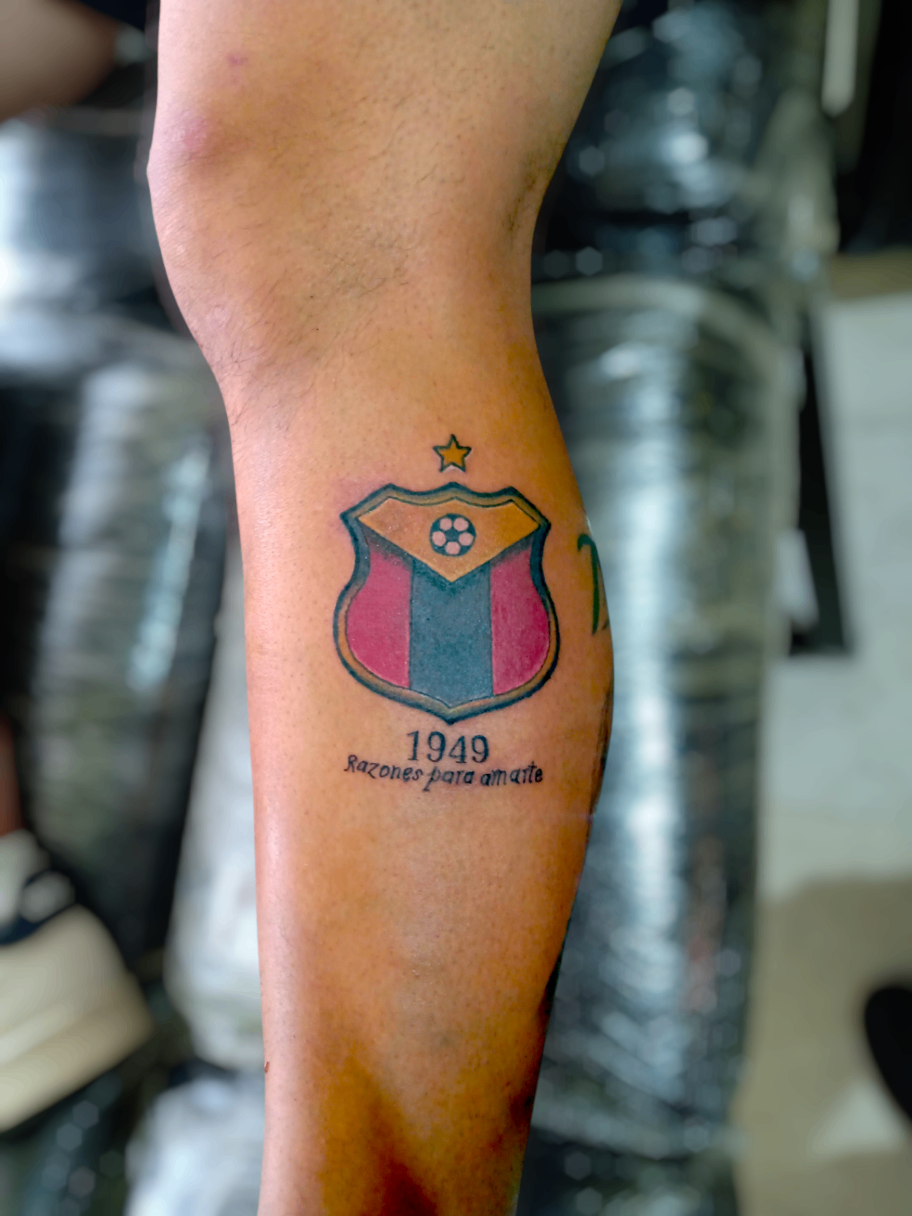 Tatuaje a color de escudo deportivo con estrella y texto 1949