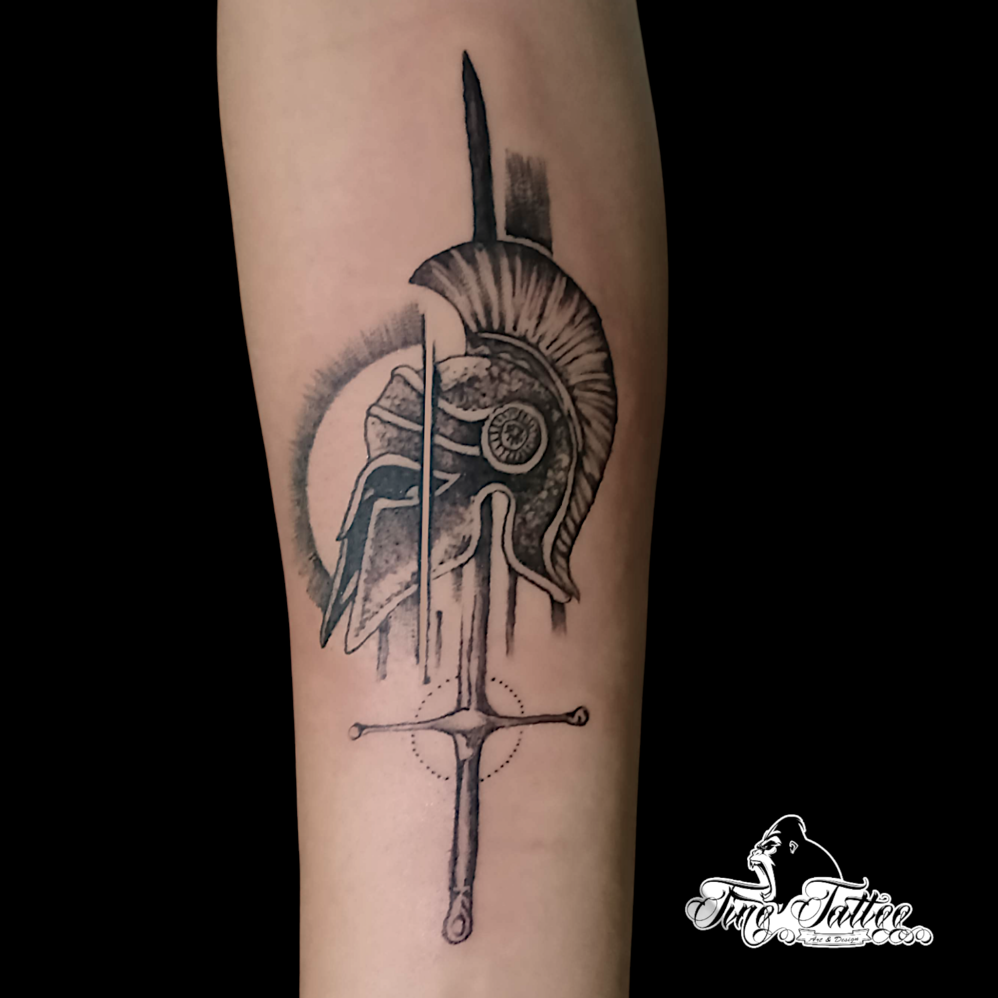 Tatuaje blackwork de casco espartano con espada vertical y fondo geométrico