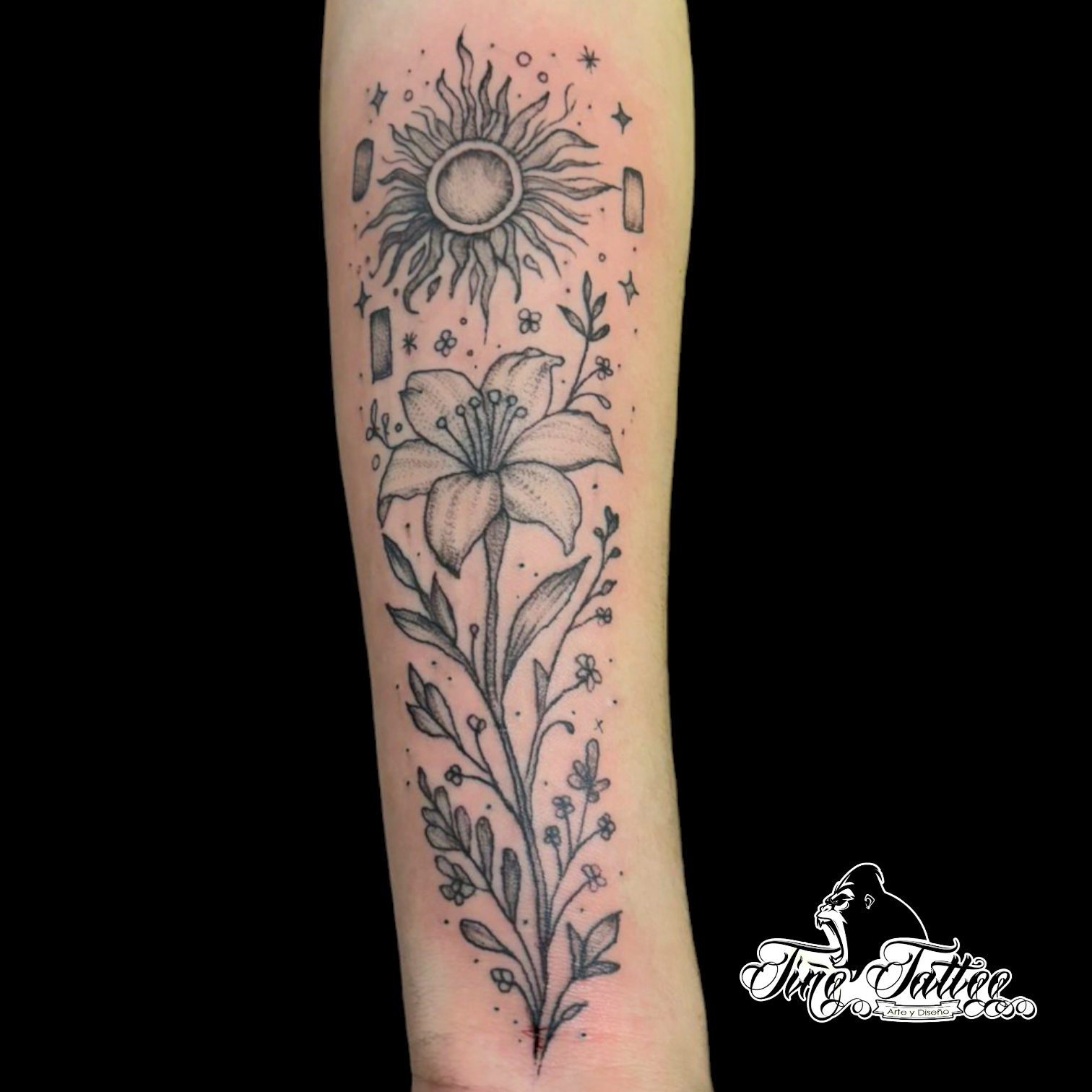 Tatuaje fineline de lirio con sol, hojas y detalles botánicos