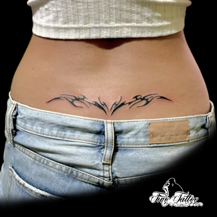 Tatuaje tribal blackwork en la zona lumbar