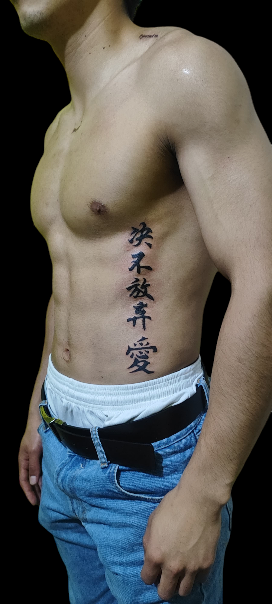 Tatuaje vertical de caracteres japoneses en la zona de las costillas